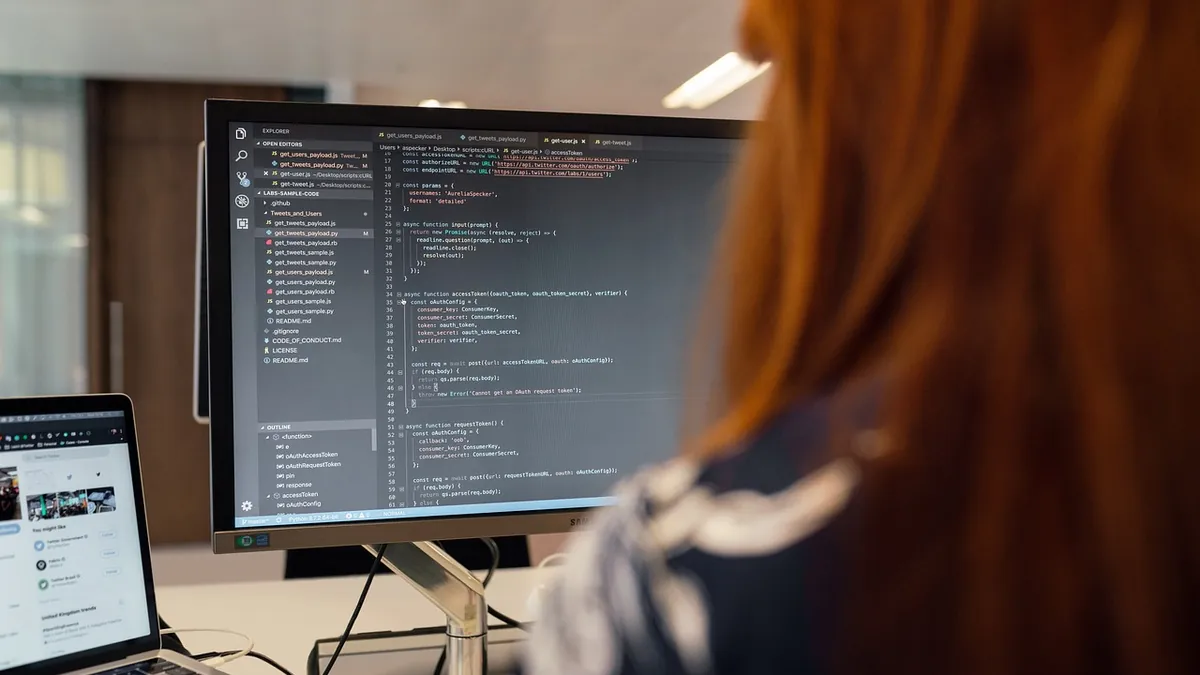 Developer reading lines of code on a large monitor while learning a programming language