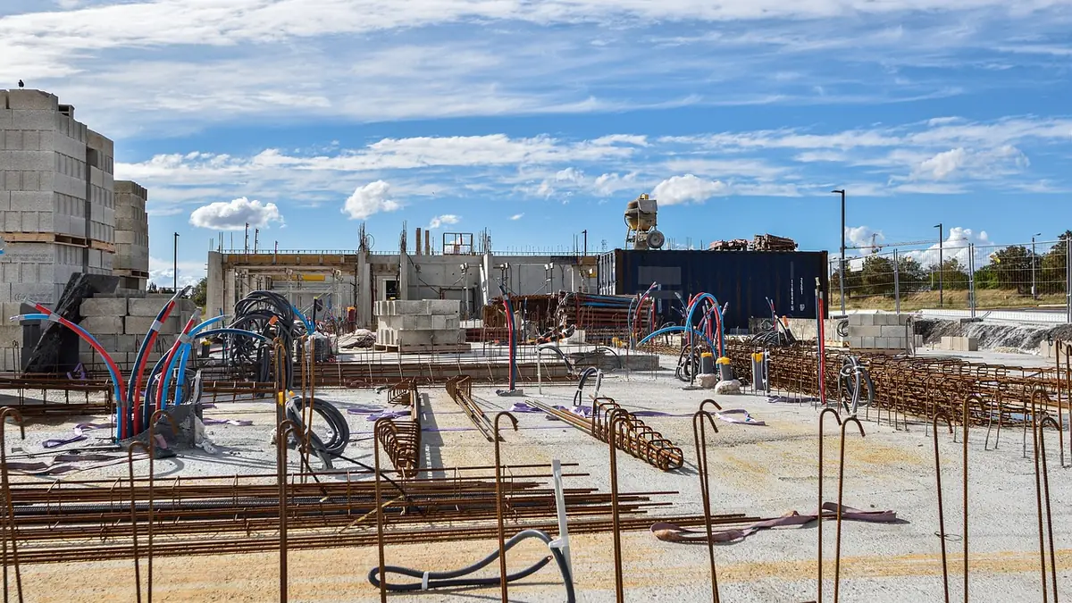 Construction site with steel rebar laid for a new concrete foundation under a blue sky