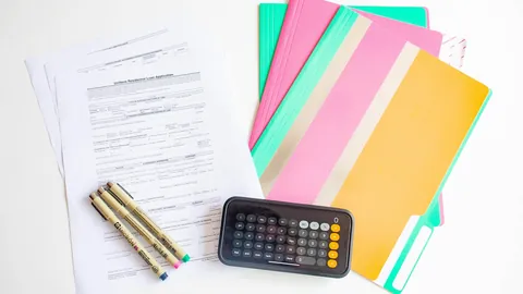 Bunte Mappen, Unterlagen und Stifte auf einem Schreibtisch für die Bewerbungsvorbereitung