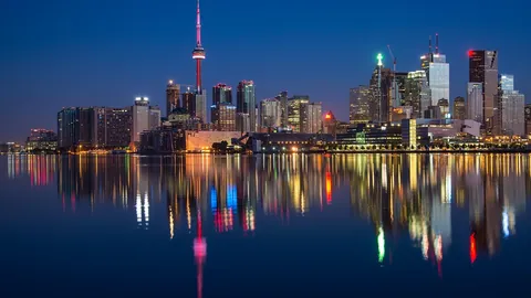 Horizonte de Toronto de noche reflejado en el lago, una de las ciudades de destino en Canadá