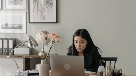 Mujer trabajando con su laptop en un escritorio de casa, lista para el trabajo remoto
