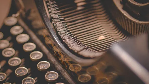 Gros plan sur les touches d'une ancienne machine à écrire, évoquant la rédaction d'une lettre de motivation