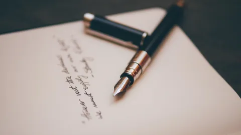 Stylo plume posé sur une lettre manuscrite, image d'une lettre de motivation bien rédigée