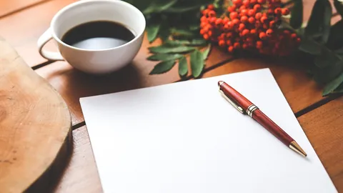 Feuille blanche et stylo sur un bureau en bois, prête pour remplir un modèle de lettre