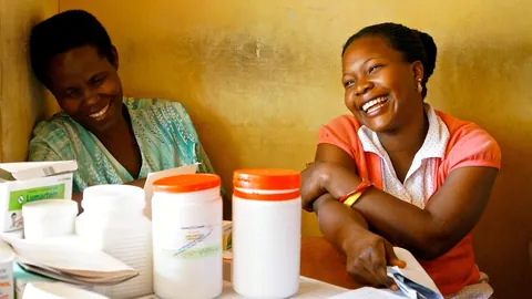 Two smiling health workers share a moment at a clinic table, the warmth nurse interviewers look for