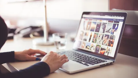 Mãos digitando em um notebook sobre a mesa ao usar um gerador de currículo online